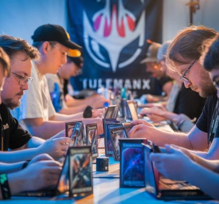 Joueurs concentrés sur leurs decks dans un tournoi Magic
